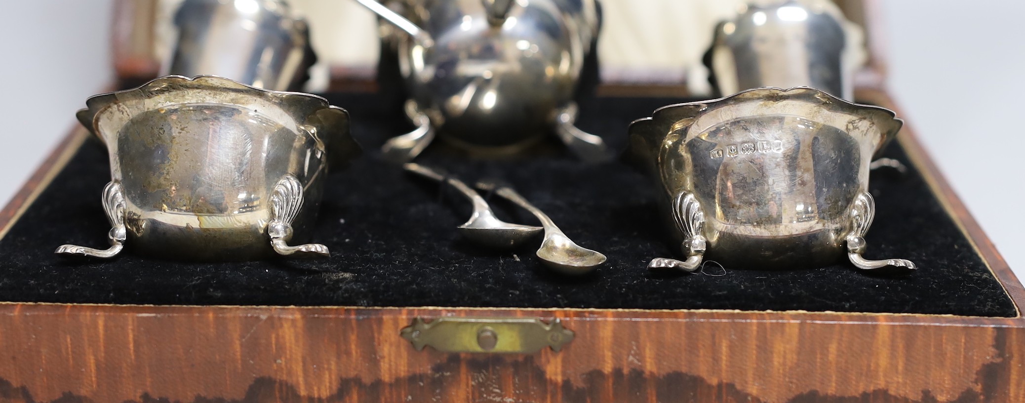 A cased 1930's silver five piece condiment set, with two associated silver spoons.